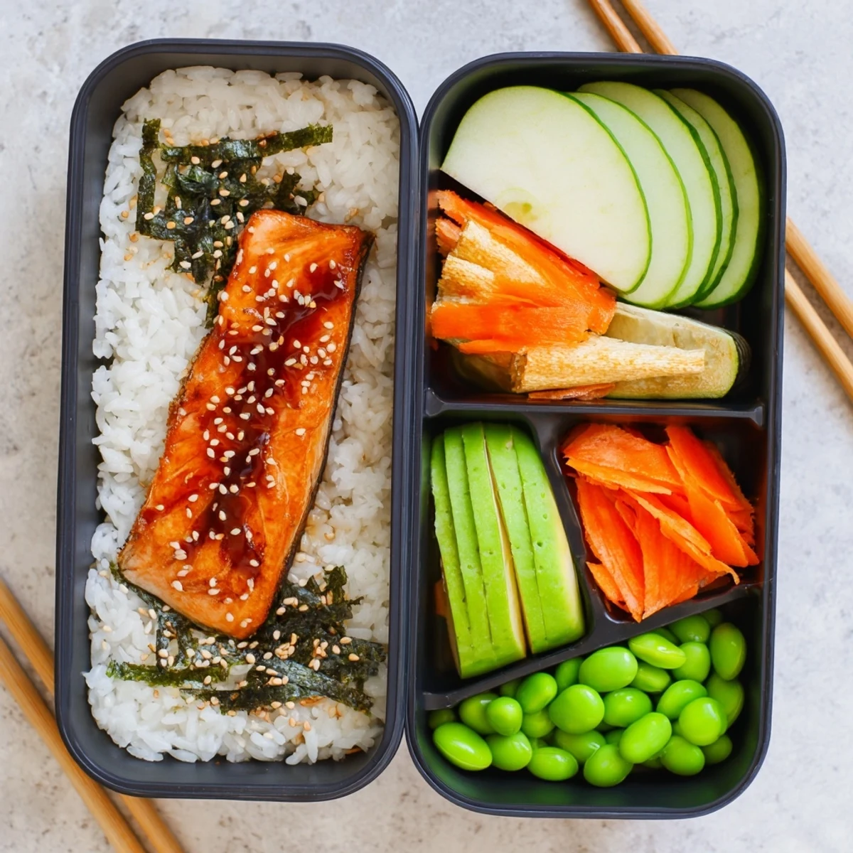 Nourishing bento breakfast featuring seasoned salmon fillets alongside steamed rice, fresh fruit, and marinated cucumber carrots