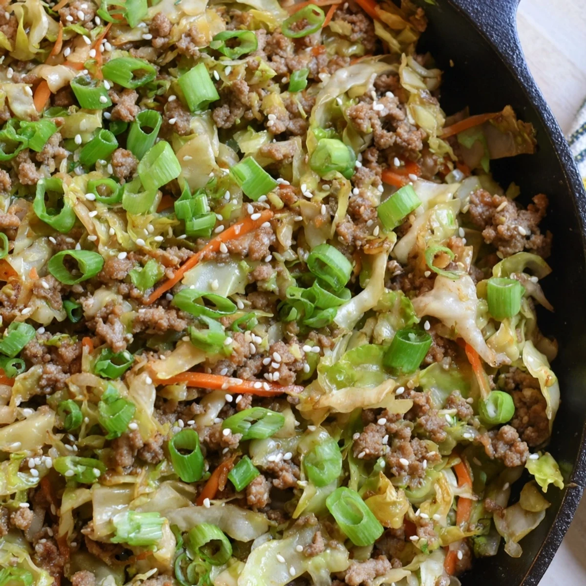 Garnished keto Egg Roll in a Bowl one skillet meal featuring sesame seeds and green onions