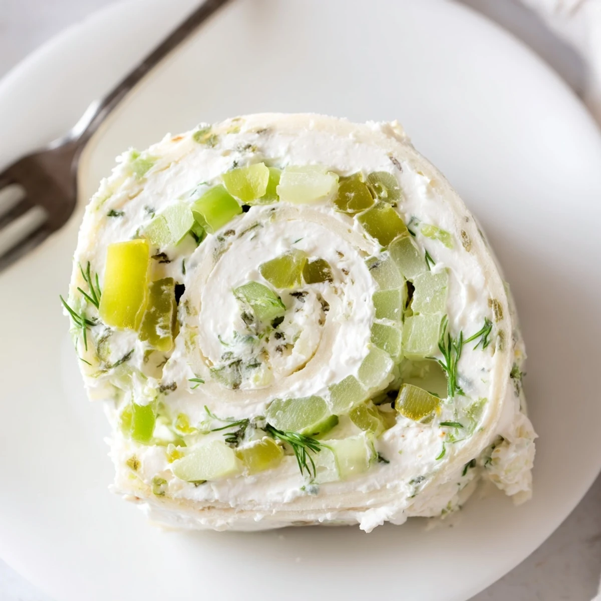 Close-up showing sliced Pickle Dip Pinwheels, tangy filling and crunchy pickles