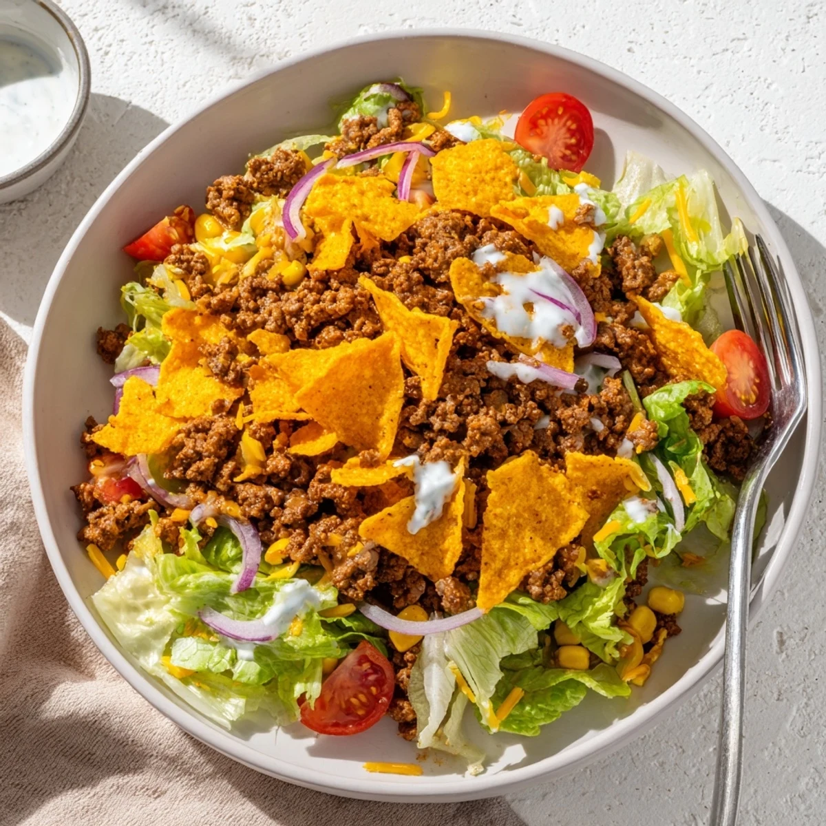 Bowl of Simple Doritos Taco Salad with bright tomatoes, creamy ranch drizzle