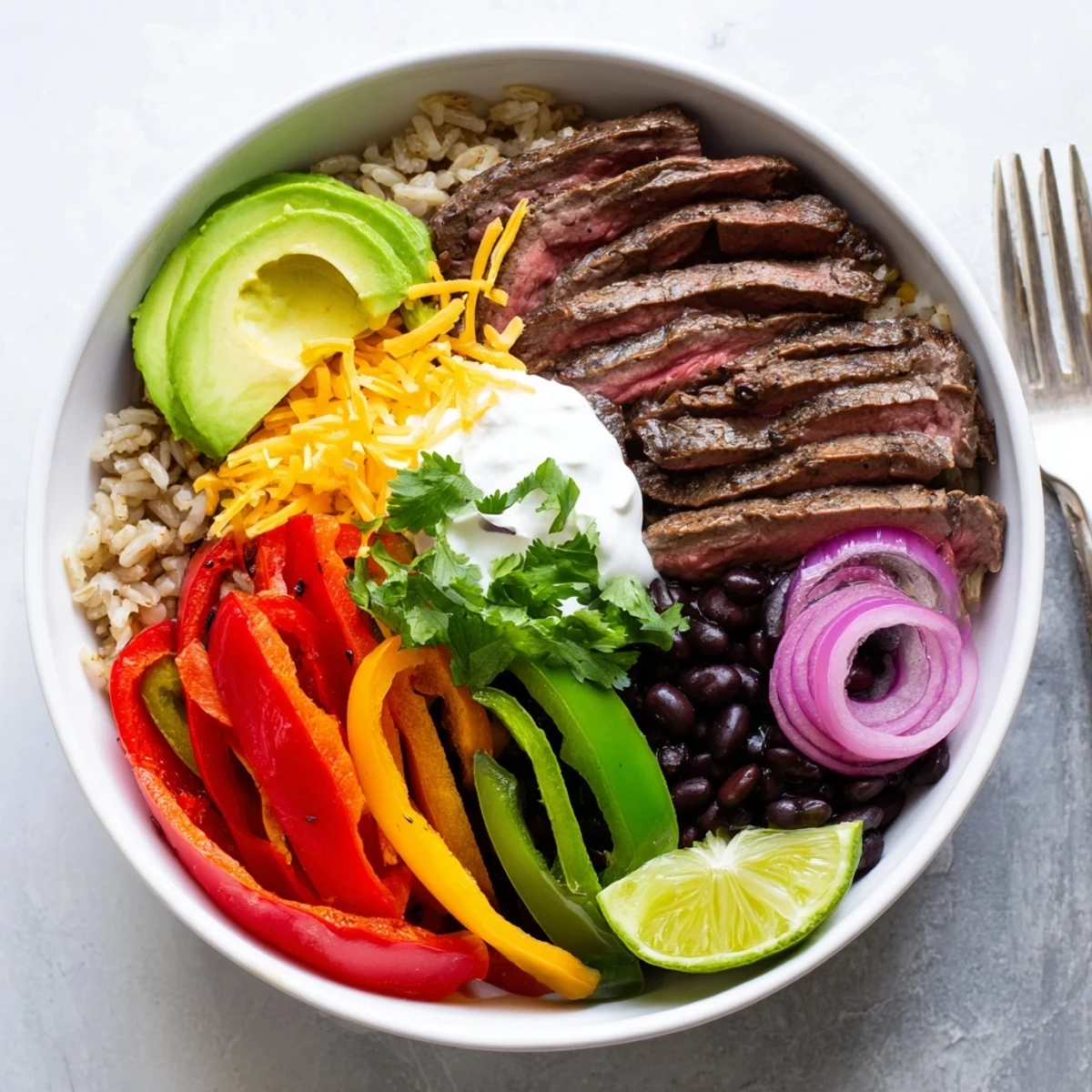 Steak Fajita Power Bowls with sizzling marinated steak, vibrant peppers and lime.