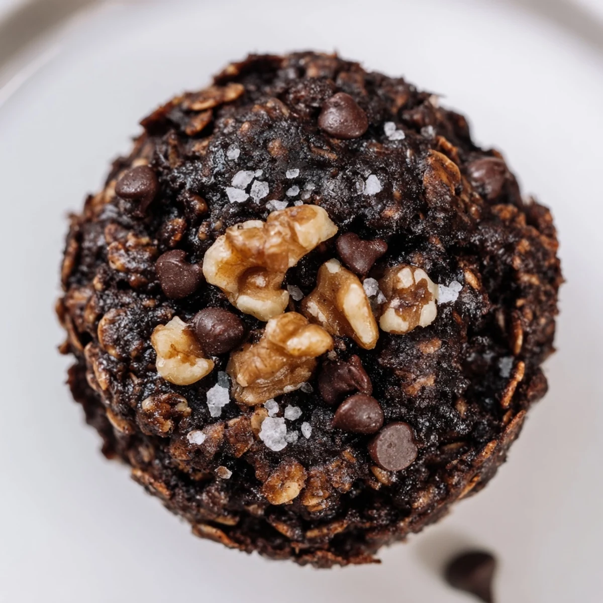 Golden dark chocolate oatmeal cups topped with melted chocolate chips and chopped walnuts