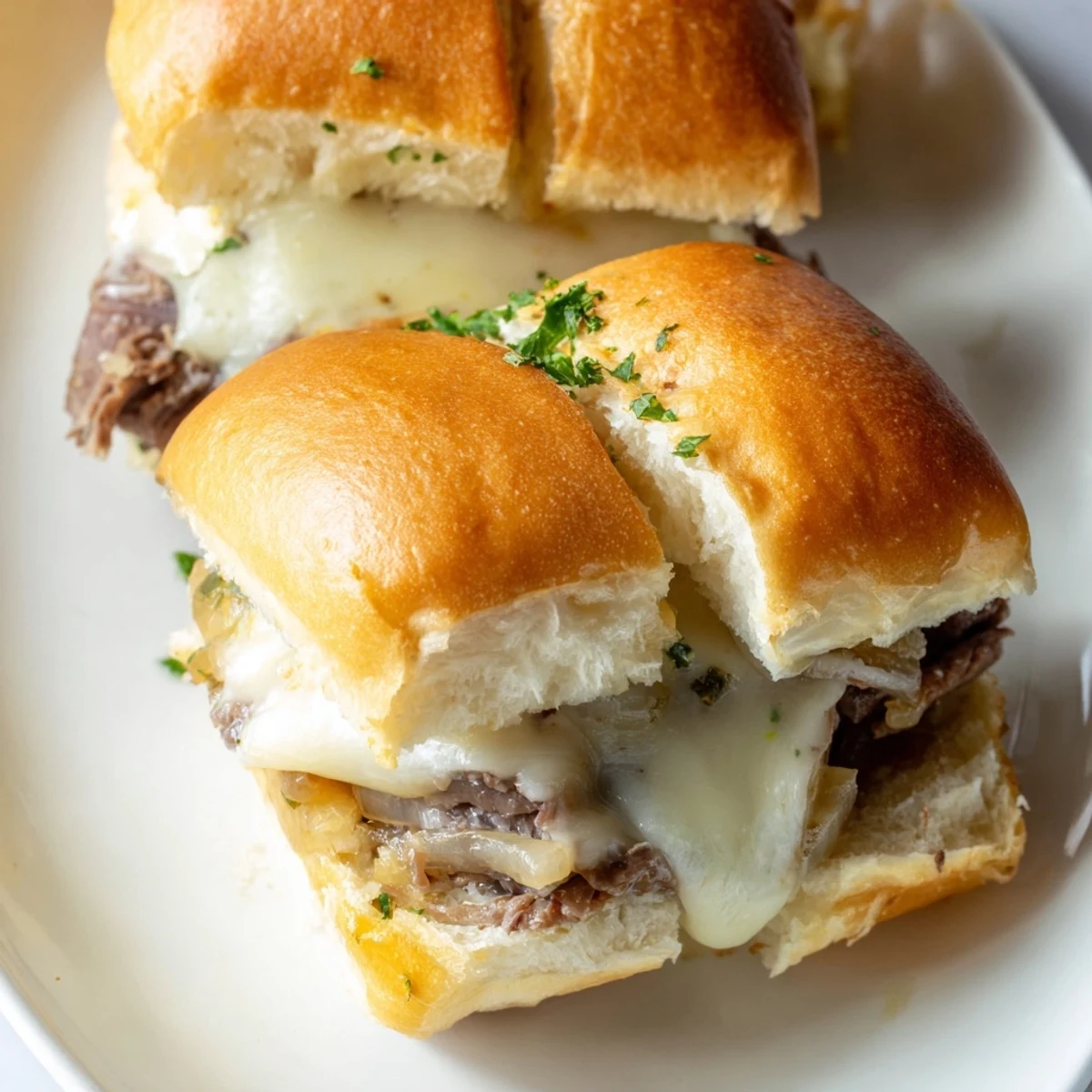 Tender roast beef French dip sliders served with rich beef broth for dipping at a casual gathering