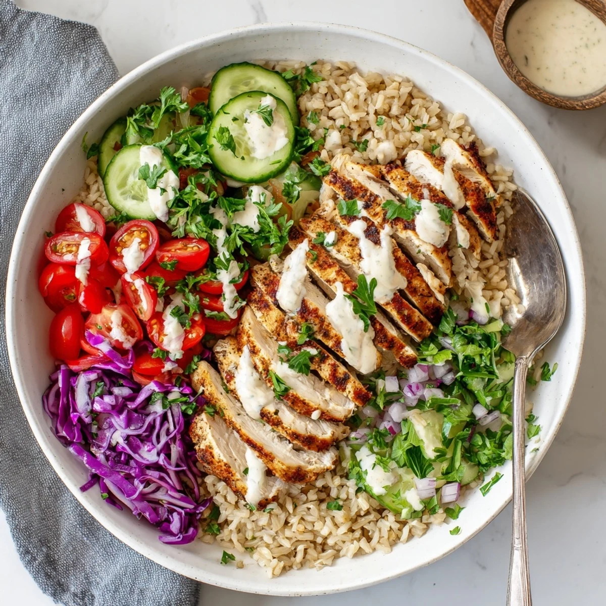 Vibrant meal prep bowl featuring seasoned protein crisp vegetables and creamy yogurt sauce in this easy healthy chicken shawarma bowl