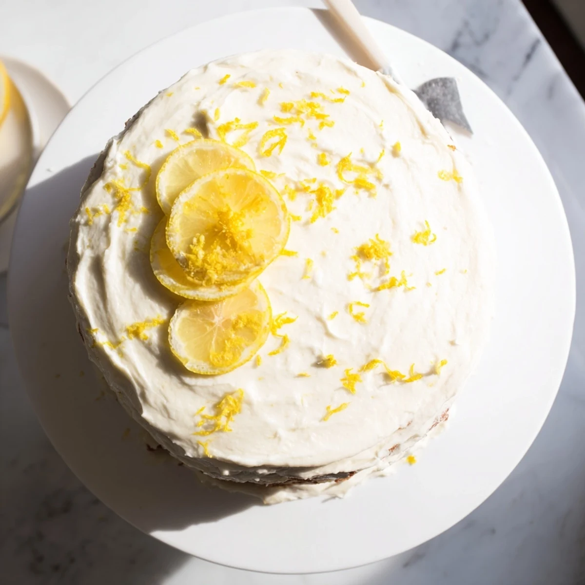 Golden lemon birthday cake layered with tangy cream cheese frosting and topped with fresh lemon slices