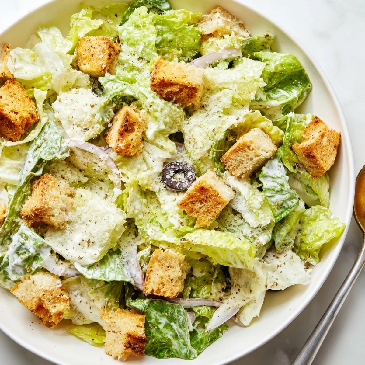 Colorful Olive Garden Salad in a wooden bowl featuring olives, cucumbers, and crunchy croutons