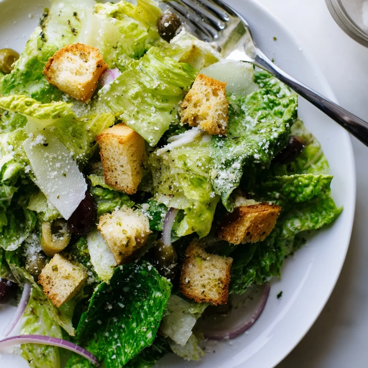 Fresh romaine Olive Garden Salad glistening with herb vinaigrette, tomatoes, and shaved Parmesan