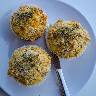 Moist citrus honey muffins topped with golden thyme crumble on a wire rack